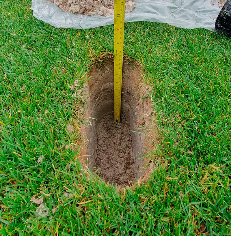 Photo d'un trou dans un terrain sportif avec un mètre